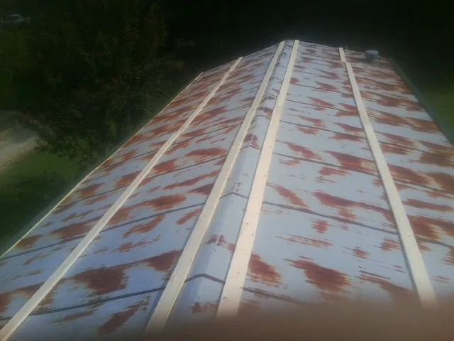 Rusted metal roof panels with new wood purlins before replacement — Storm Damage Roof Repair in Tylertown by Roofing Brothers