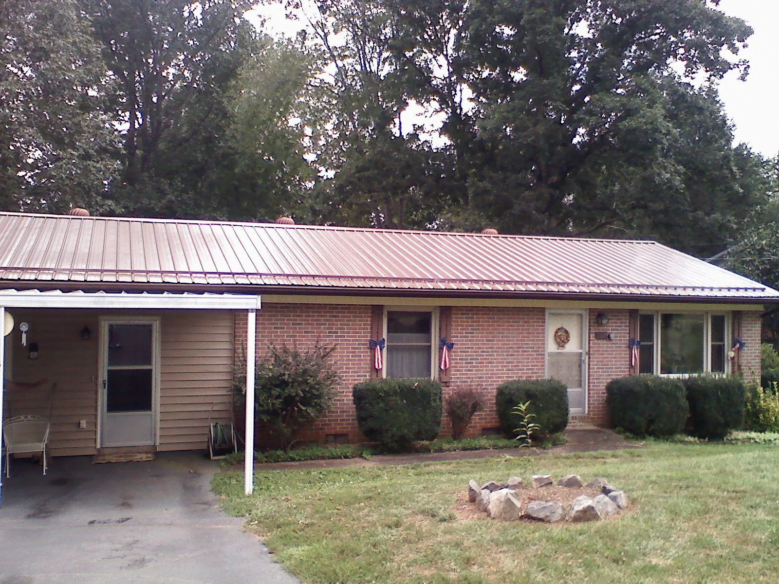 Bronze metal roof and carport on a brick ranch home — Roof Repair work by our crew in Tylertown