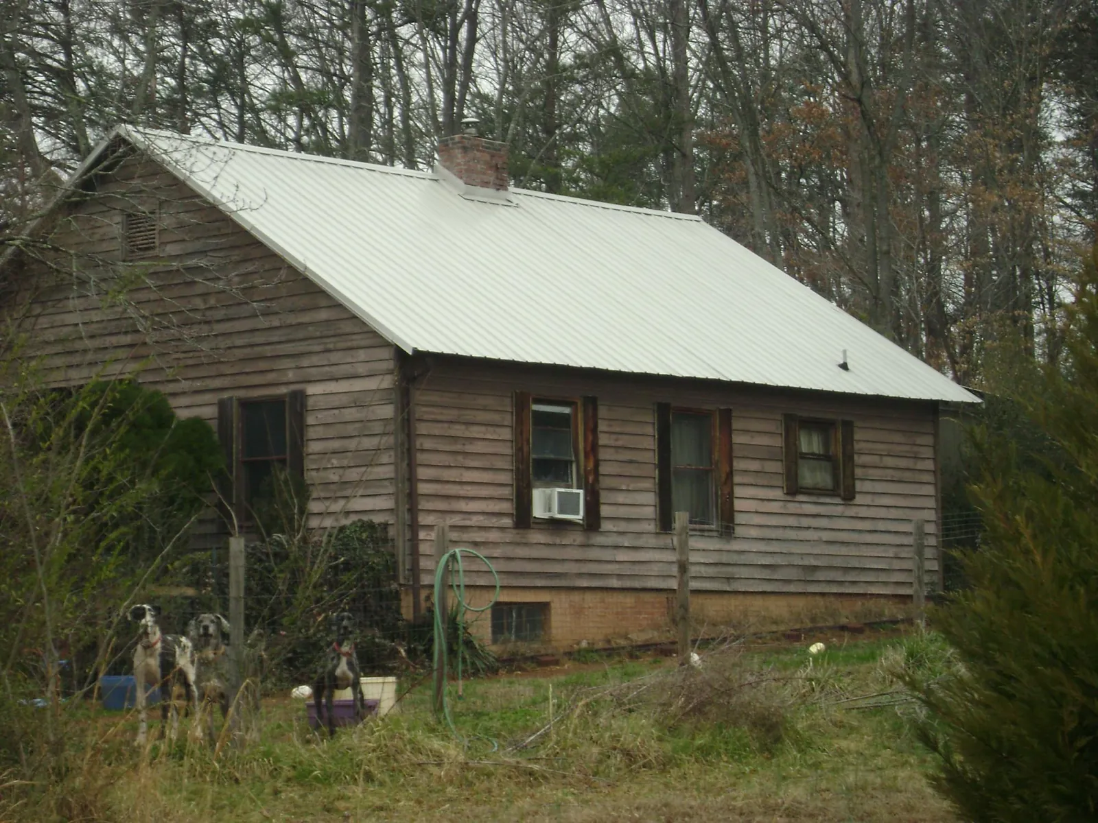 White metal roof on an old wood sided farmhouse, from a Metal Roof Installation job in Tylertown